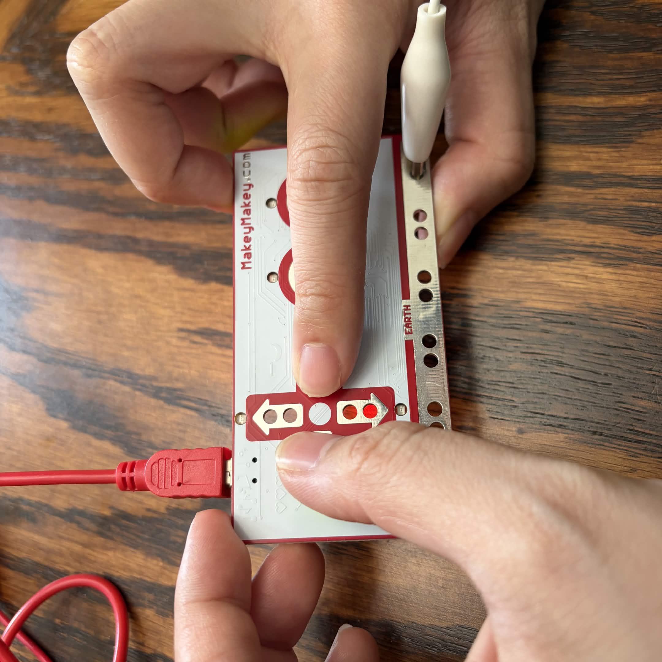 Holding the Makey Makey with two inputs. This can work!