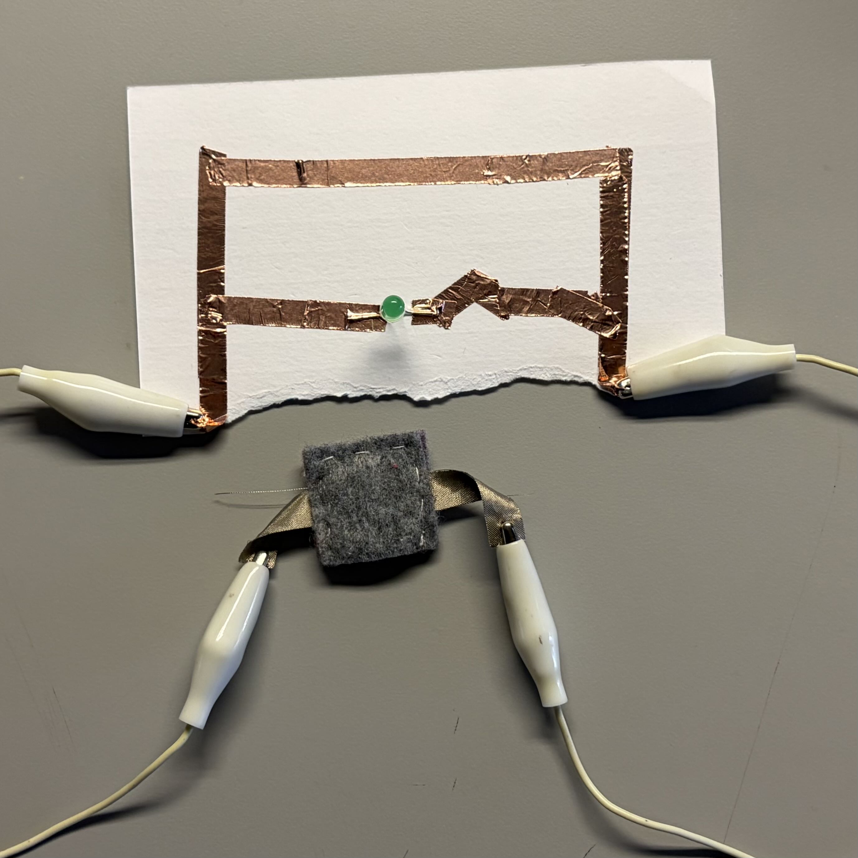 Initial tests of experimenting with alligator clasps and the battery inside felt. I also tried out a
                jagged connection line